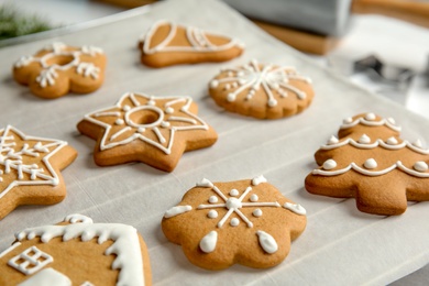 Photo of Tasty decorated Christmas cookies on baking parchment