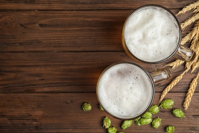 Photo of Flat lay composition with tasty beer and fresh green hops on wooden background. Space for text