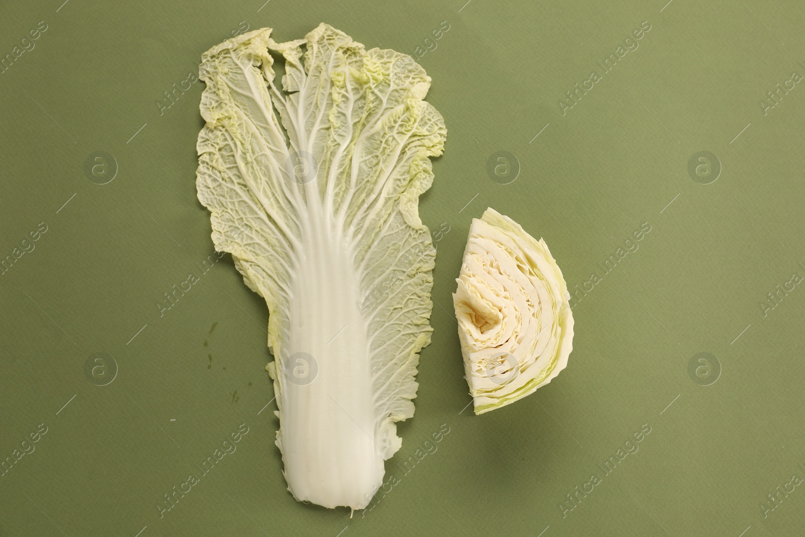 Photo of Cut fresh Chinese cabbage and leaf on olive background, flat lay