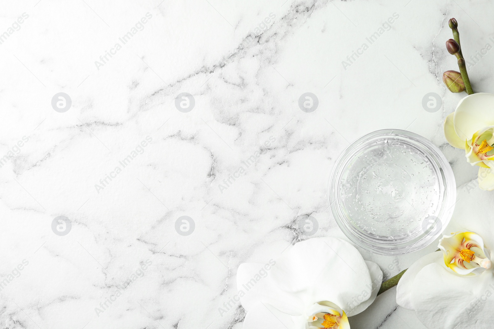 Photo of Flat lay composition with cosmetic gel and beautiful flowers on white marble table. Space for text