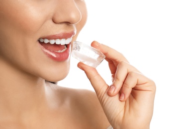 Photo of Young woman with ice cube on white background, closeup