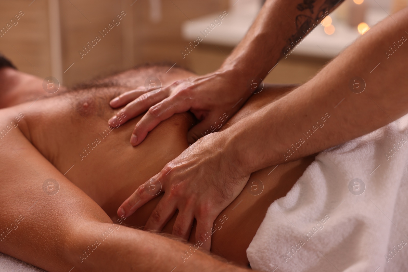 Photo of Man receiving professional belly massage in spa salon, closeup