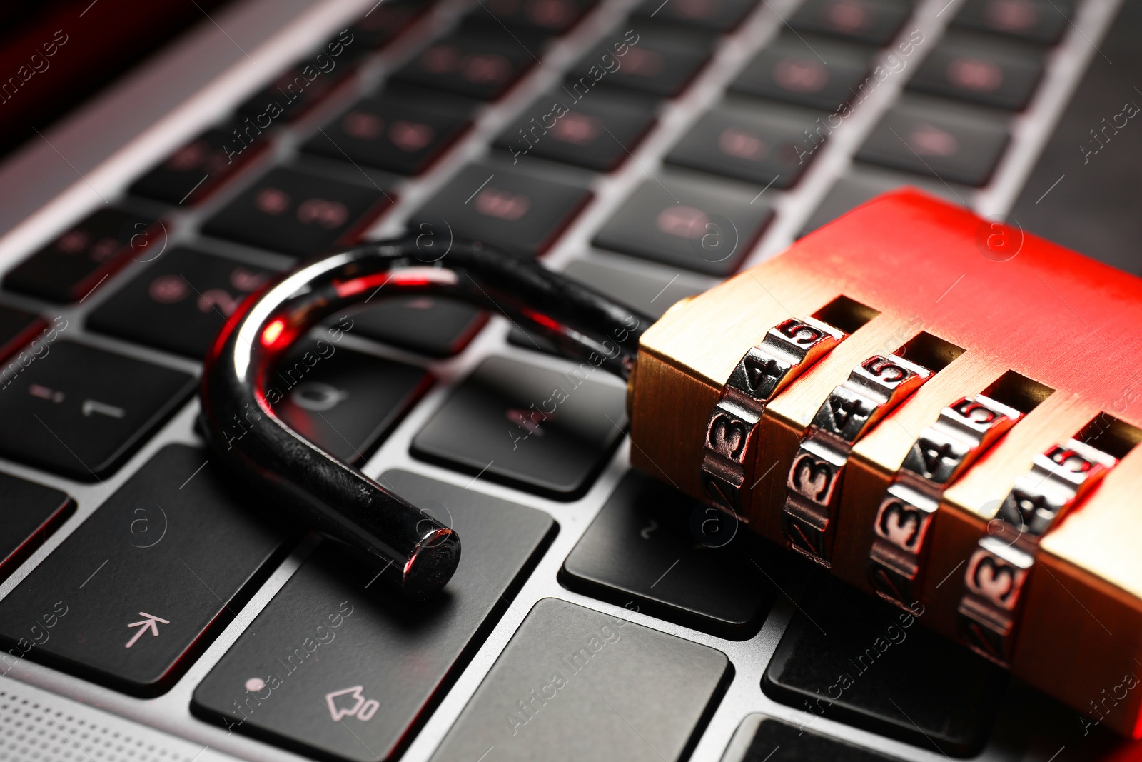 Photo of Cyber security. Metal combination padlock on laptop, closeup