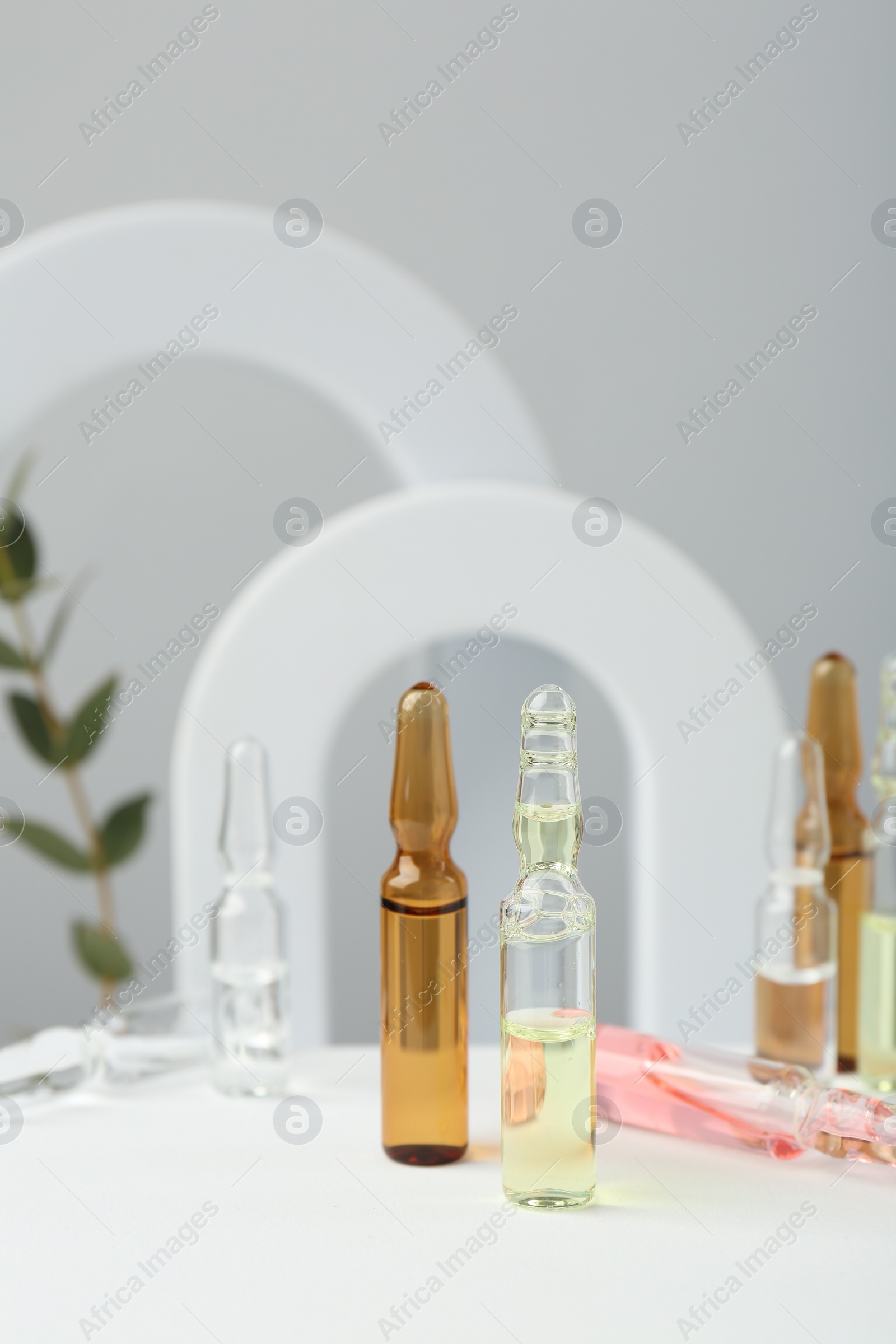 Photo of Stylish presentation of different skincare ampoules on white background