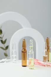 Stylish presentation of different skincare ampoules on white background