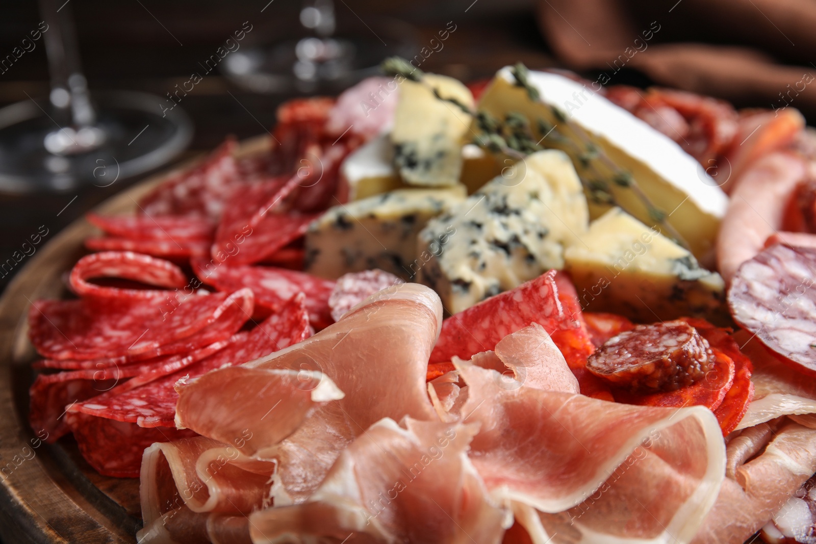 Photo of Tasty prosciutto with other delicacies served on table, closeup