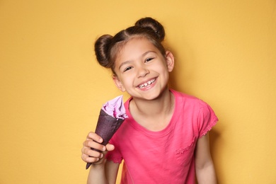 Photo of Adorable little girl with delicious ice cream against color background