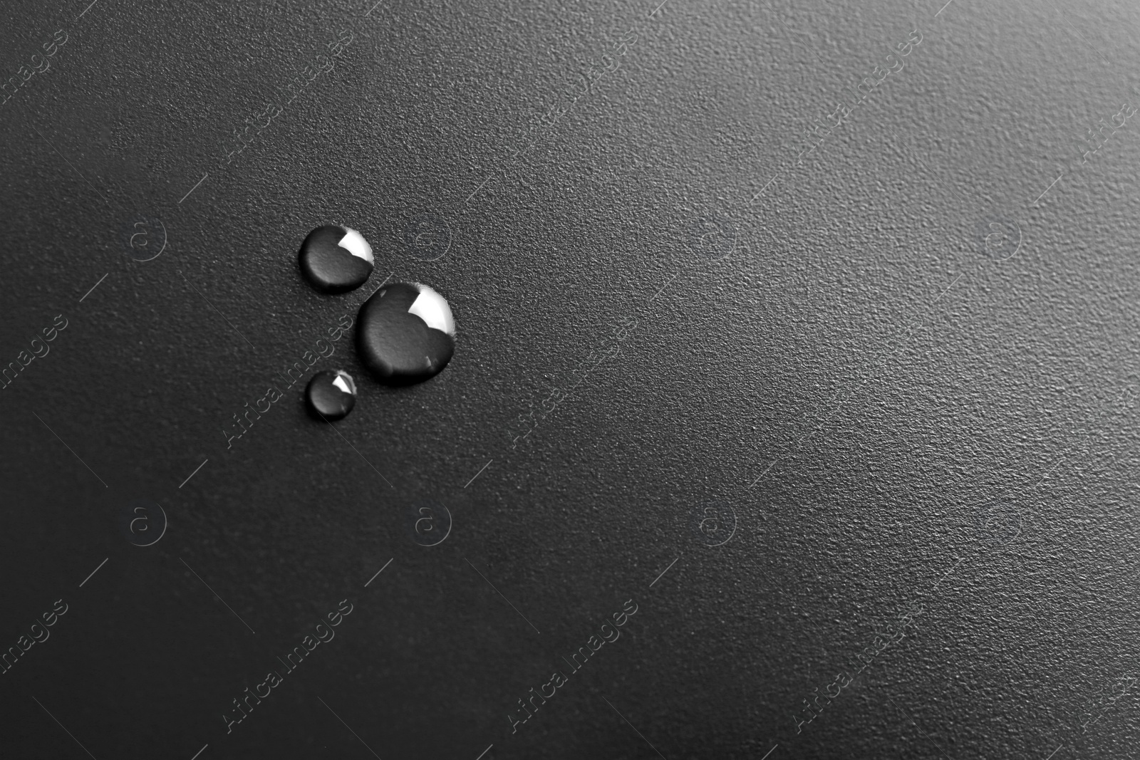 Photo of Water drops on black background, top view. Space for text