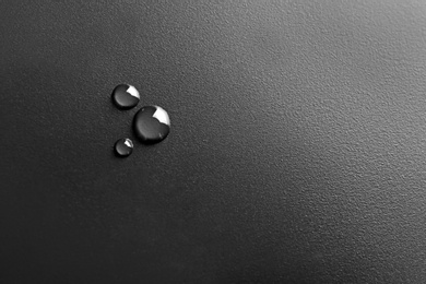 Photo of Water drops on black background, top view. Space for text