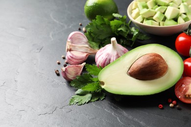 Fresh guacamole ingredients on black table. Space for text