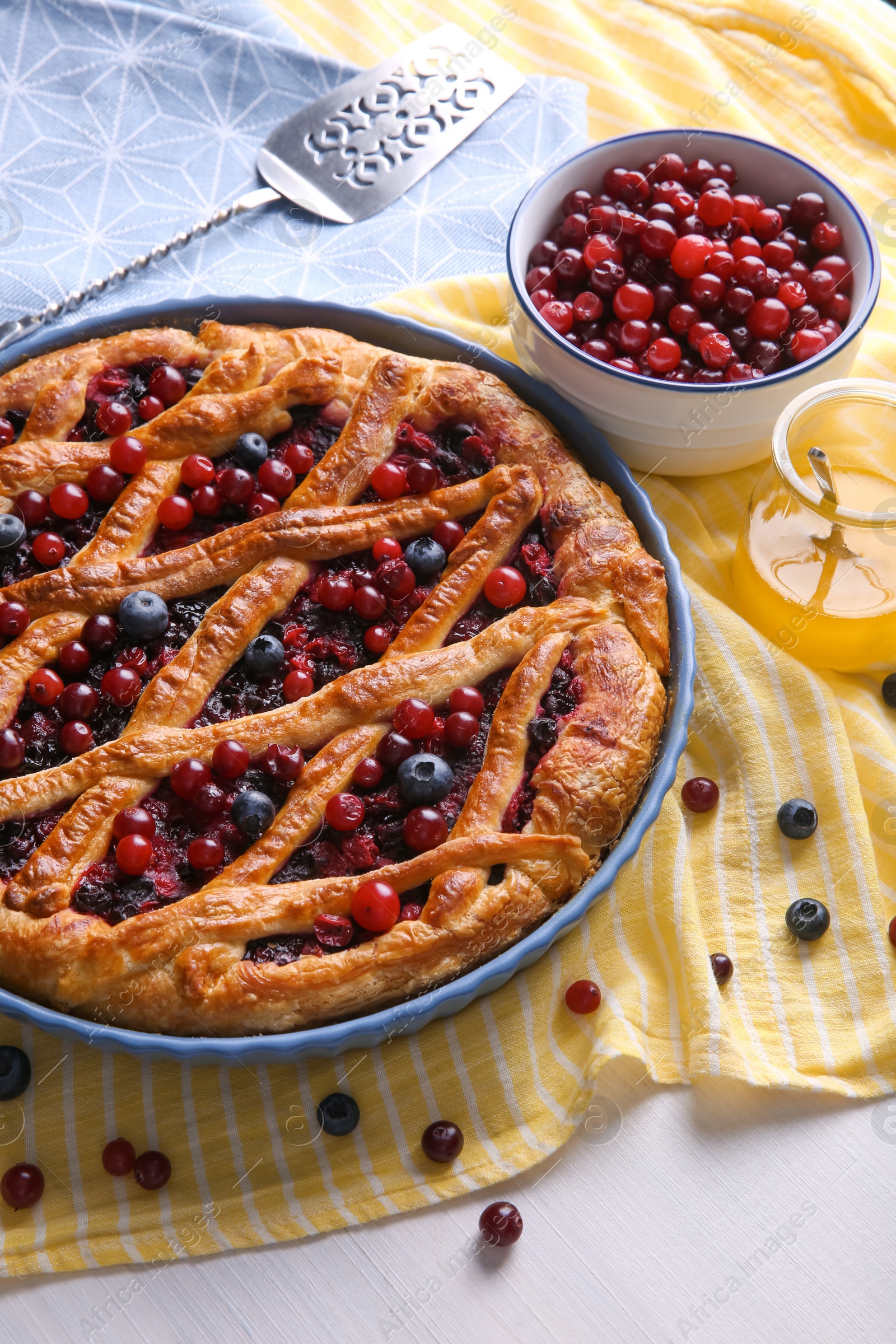 Photo of Delicious currant pie and fresh berries on white wooden table