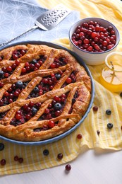 Delicious currant pie and fresh berries on white wooden table