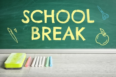 Image of Text School Break and drawings on green chalkboard near table. Seasonal holidays