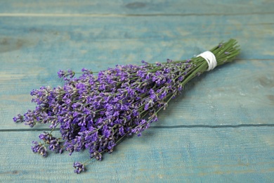 Photo of Beautiful tender lavender flowers on blue wooden table