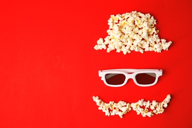 Photo of Face made of popcorn and glasses on color background, top view with space for text. Cinema snack