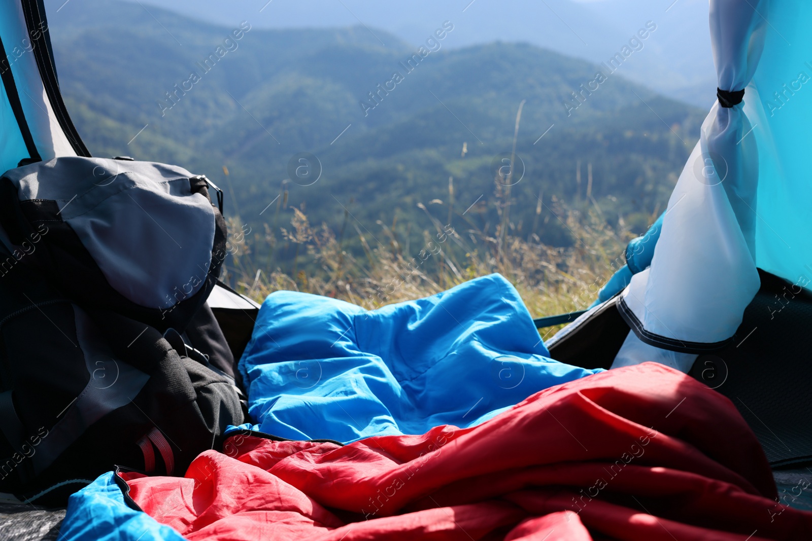 Photo of Camping tent with sleeping bag in mountains, view from inside