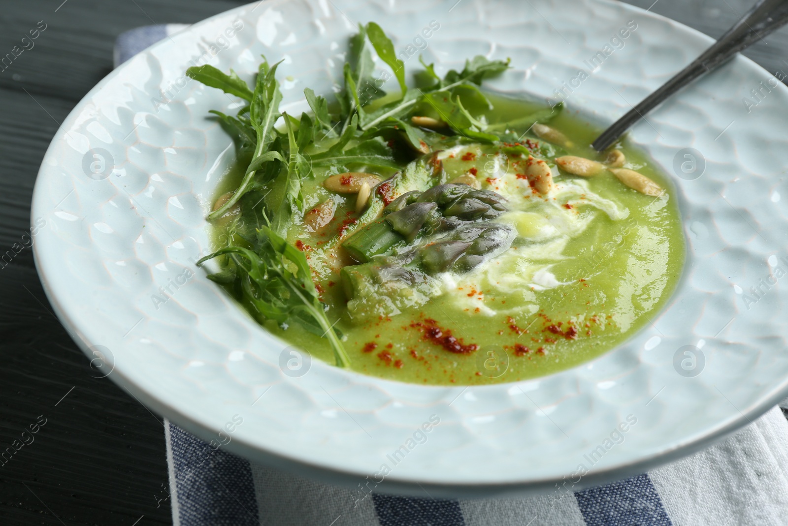 Photo of Delicious asparagus soup served on table, closeup