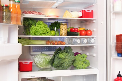 Photo of Open refrigerator with fresh food on shelves