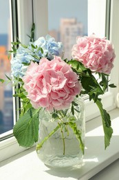 Bouquet with beautiful hortensia flowers on window sill