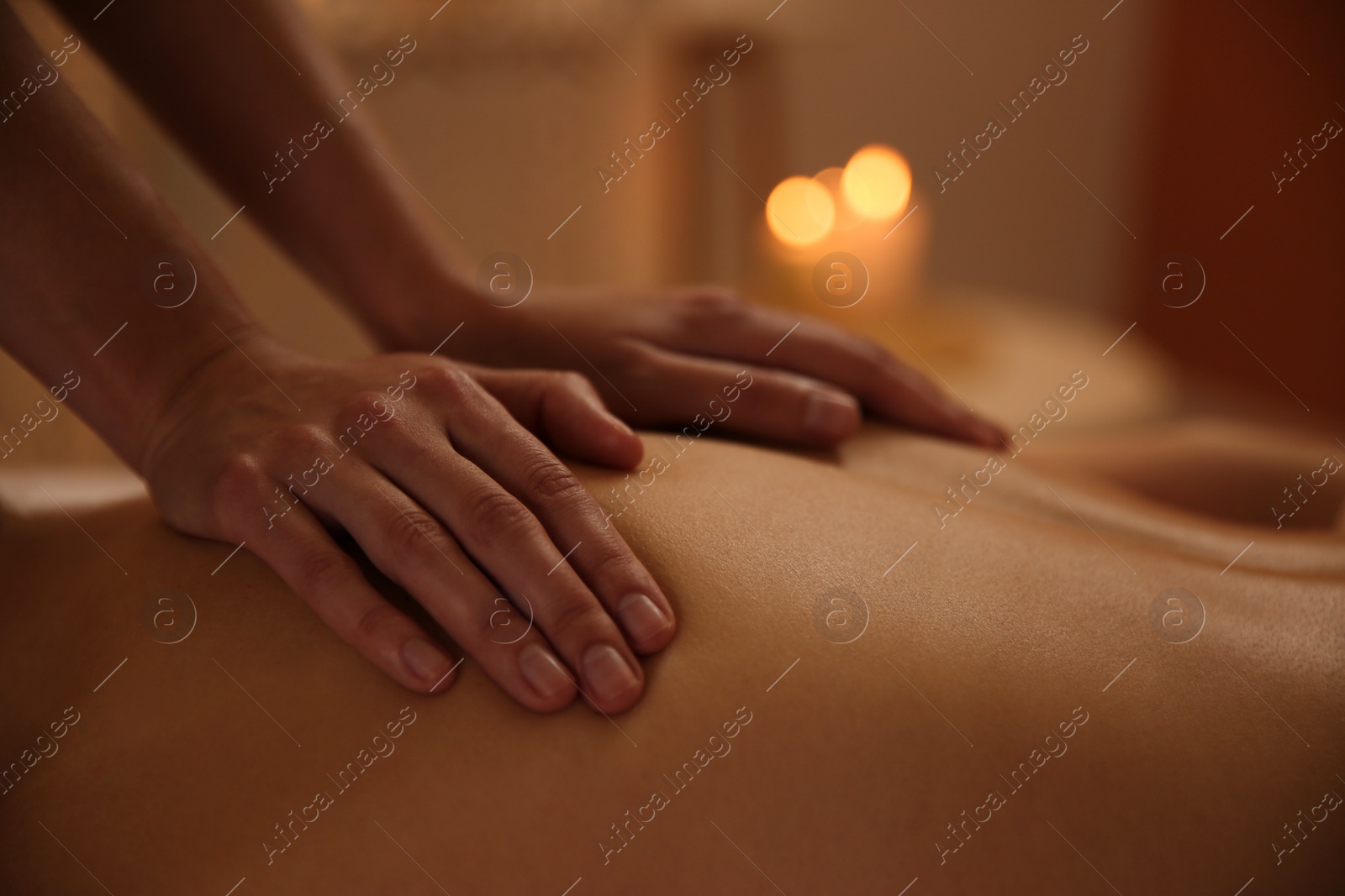 Photo of Young woman receiving back massage in spa salon, closeup