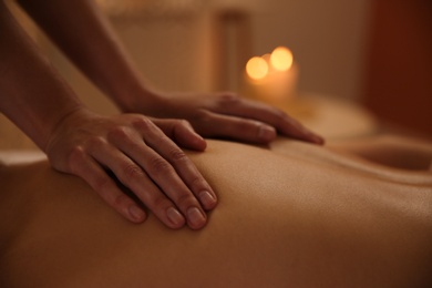 Young woman receiving back massage in spa salon, closeup