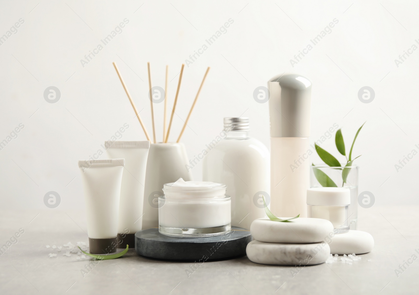 Photo of Composition with skin care products and spa stones on light background