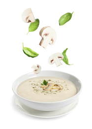 Image of Fresh mushrooms and basil falling into bowl with homemade soup on white background