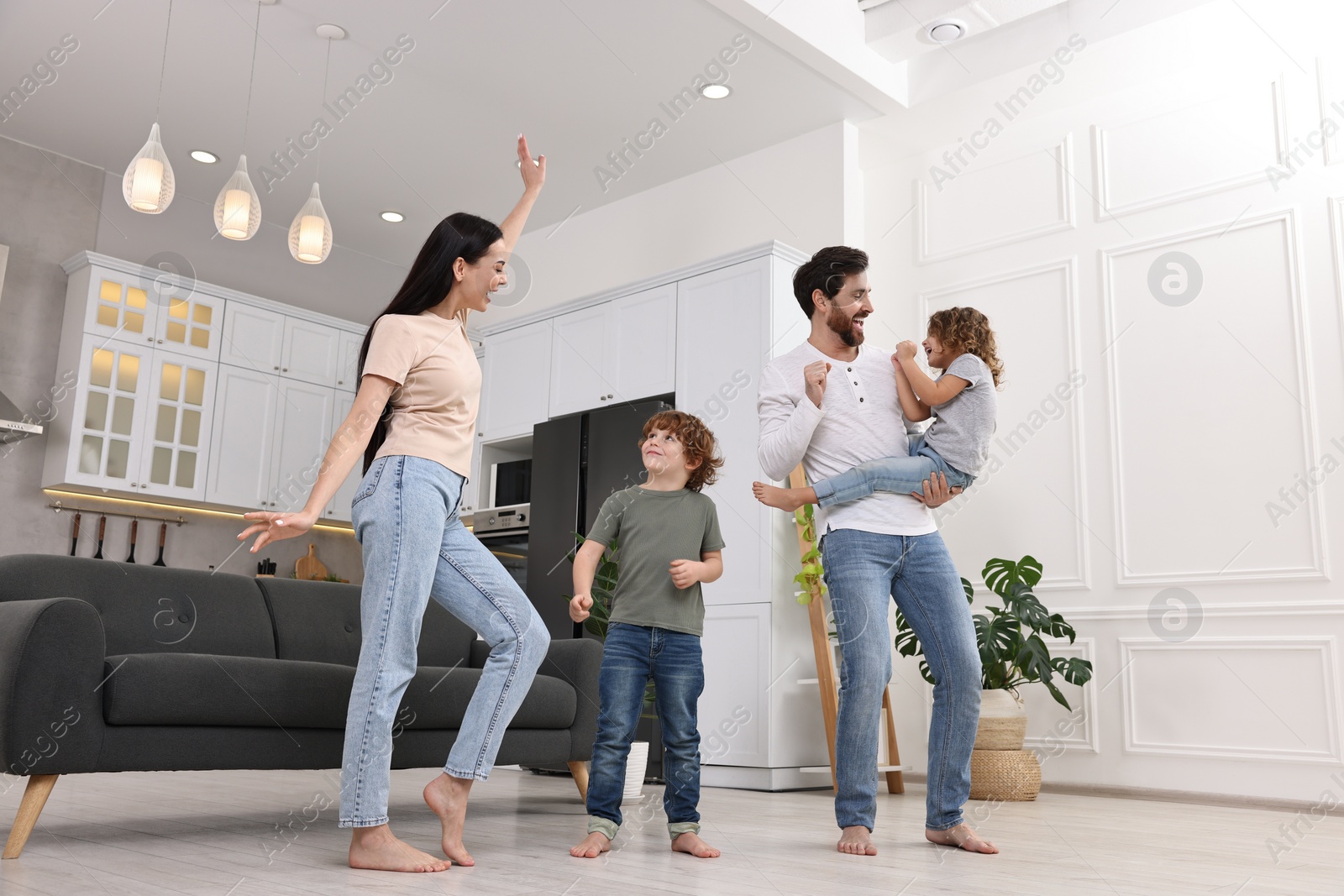 Photo of Happy family dancing and having fun at home, low angle view