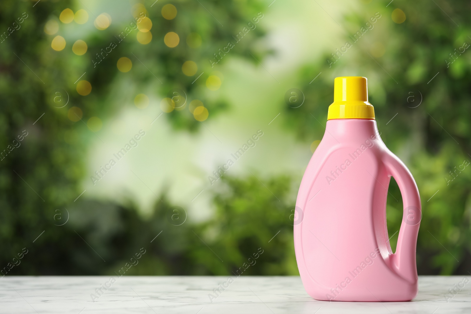 Photo of Detergent on white table outdoors, space for text