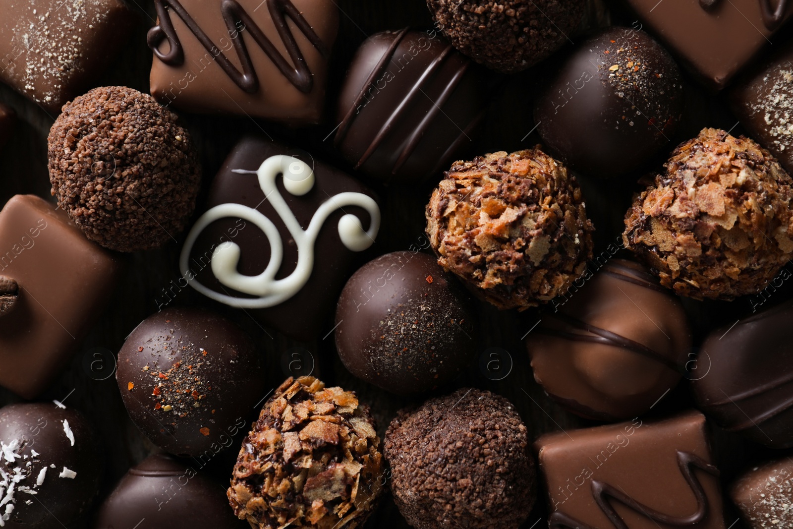 Photo of Different delicious chocolate candies as background, top view