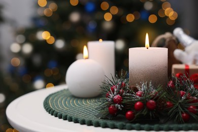 Photo of Beautiful burning candles and Christmas decor on white table indoors, space for text