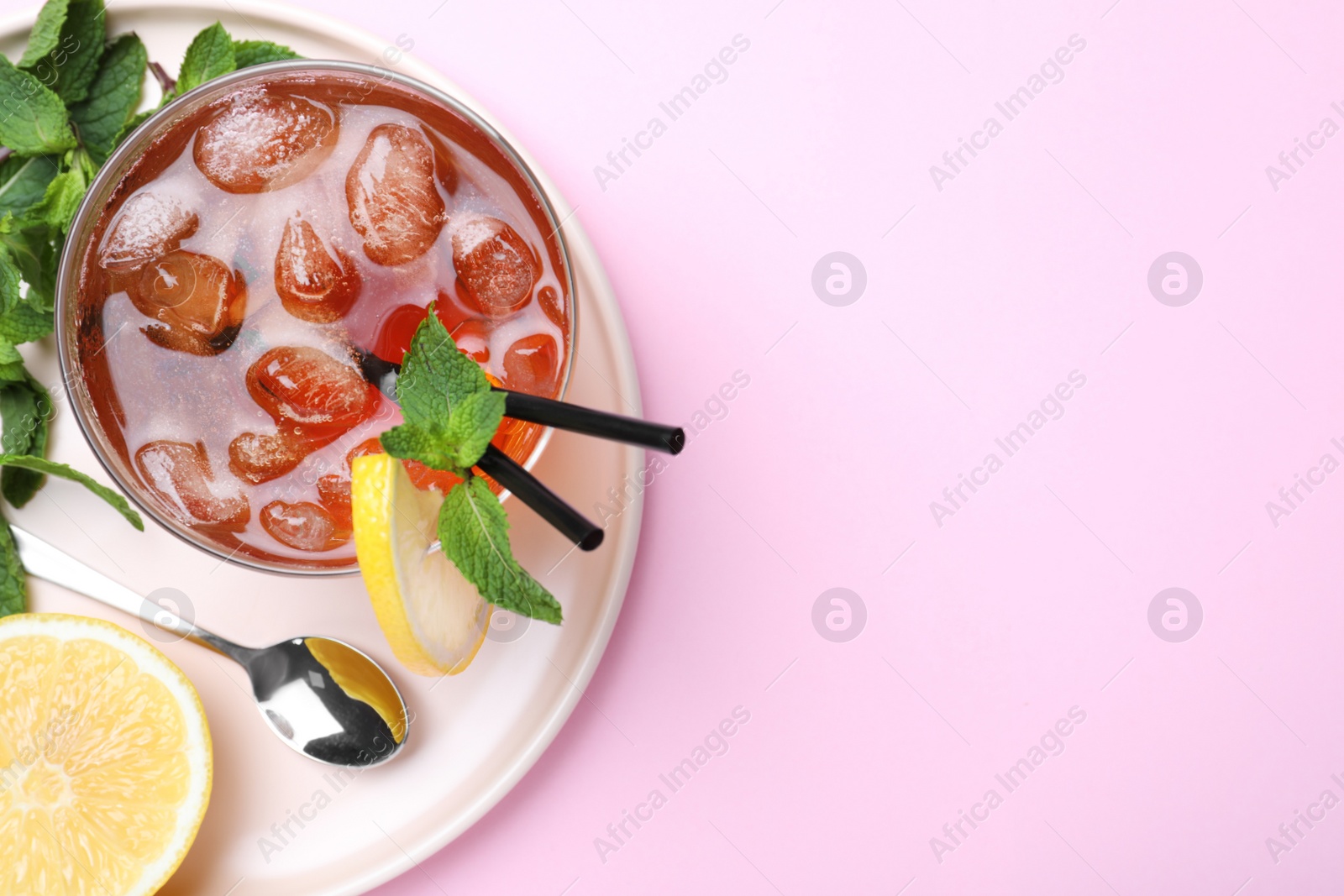 Photo of Delicious iced tea with lemon and mint on pink background, top view. Space for text