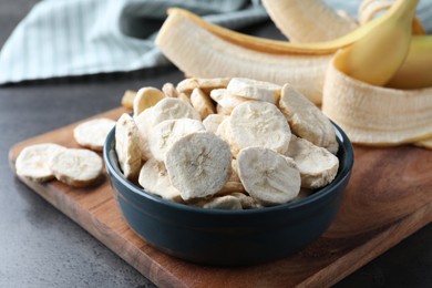 Photo of Freeze dried and fresh bananas on grey table, closeup