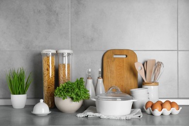 Photo of Set of different cooking utensils and products on grey countertop in kitchen
