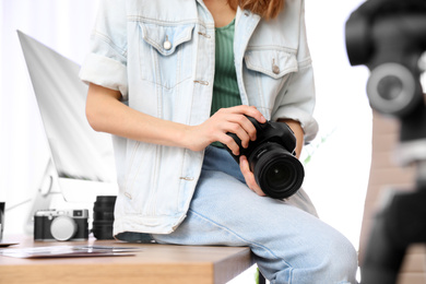 Photo of Professional photographer with camera working in office, closeup