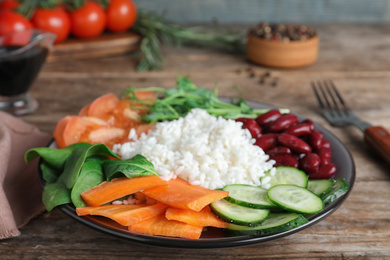 Photo of Tasty rice with beans and vegetables on wooden table, closeup