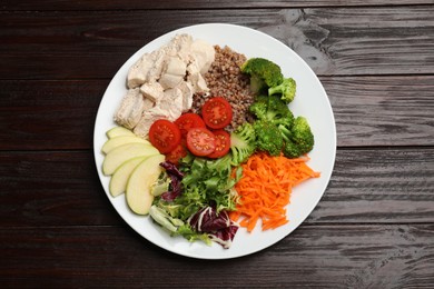 Photo of Balanced diet and healthy foods. Plate with different delicious products isolated on wooden table, top view