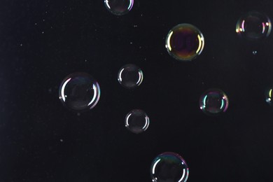 Photo of Beautiful transparent soap bubbles on dark background