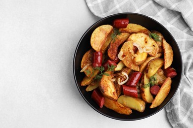 Photo of Delicious baked potato with thin dry smoked sausages, onion and dill in bowl on gray table, top view. Space for text