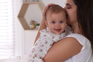 Photo of Happy young mother with her baby daughter in nursery