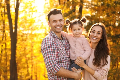 Photo of Happy family with little daughter in park. Autumn walk