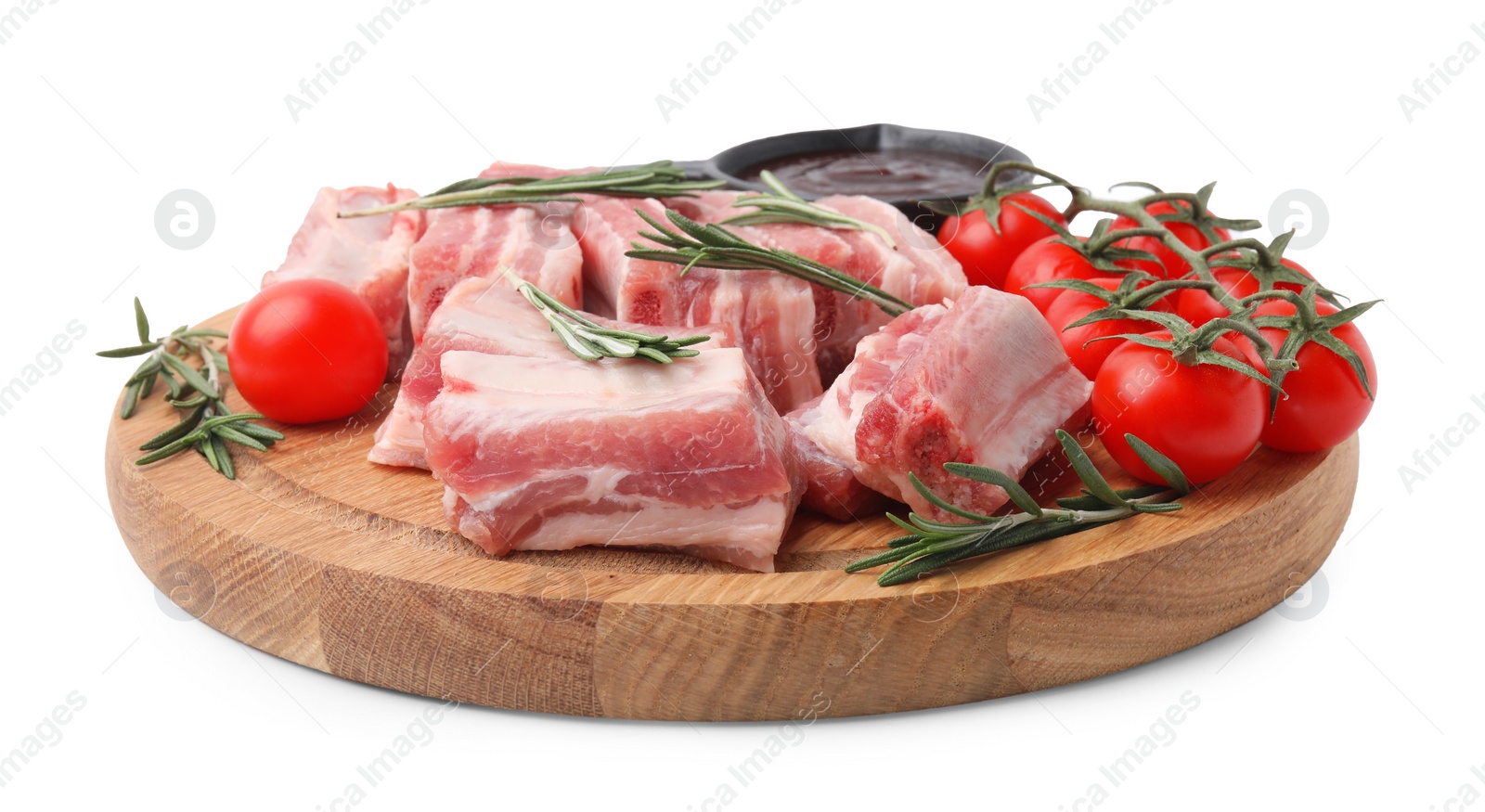 Photo of Cut raw pork ribs with rosemary, tomatoes and sauce isolated on white