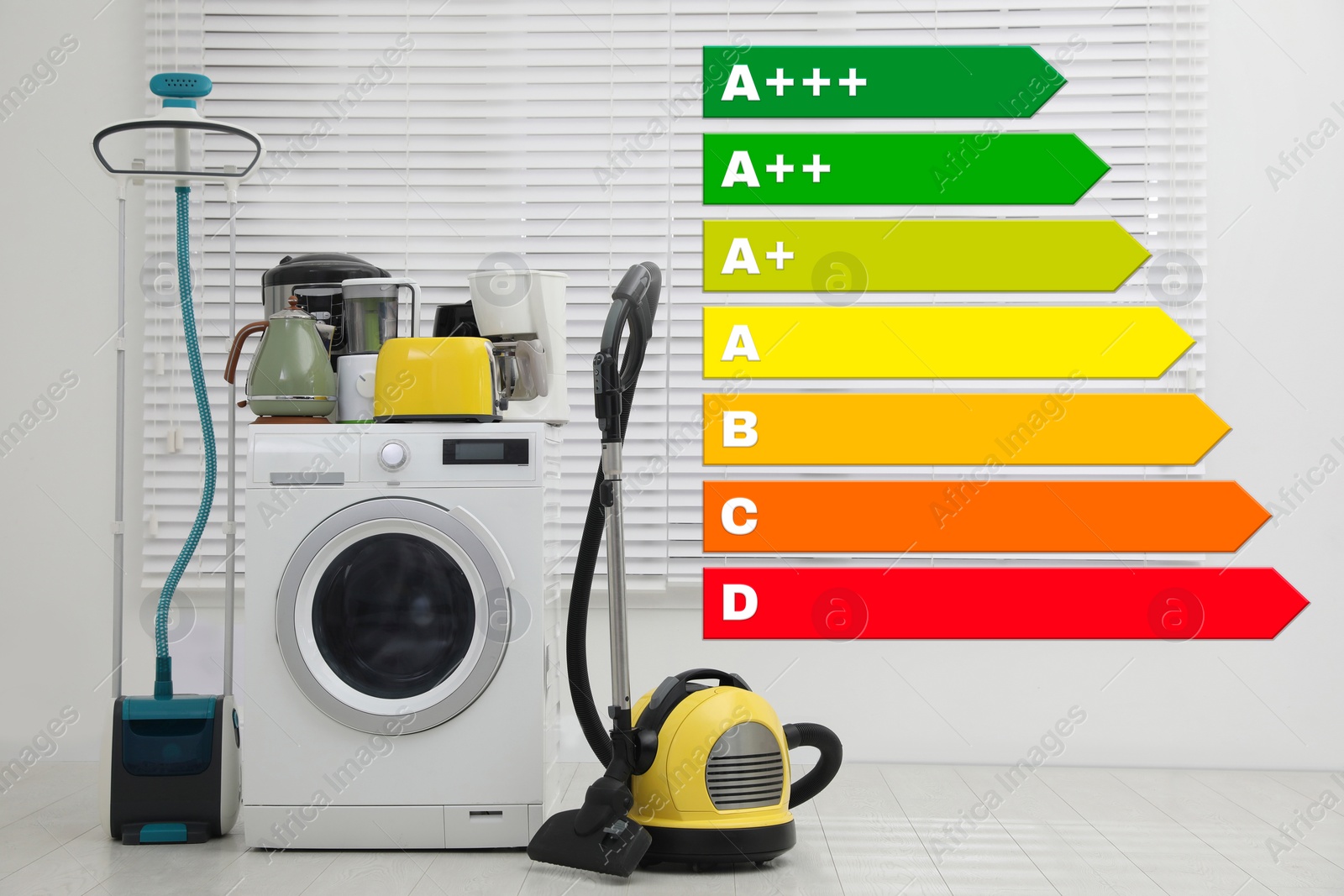Image of Energy efficiency rating label and different household appliances near window indoors