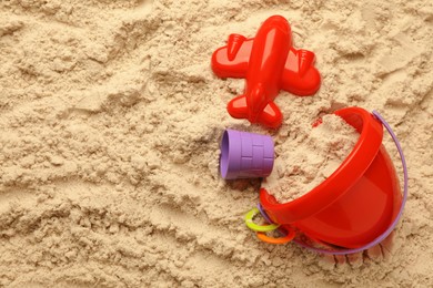 Flat lay of beach toy kit on sand, space for text. Outdoor play