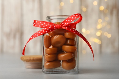 Photo of Sweet candies in jar on light grey table