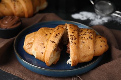 Photo of Tasty croissant with chocolate and sesame seeds on table