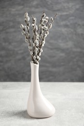 Photo of Beautiful pussy willow branches in vase on light grey table