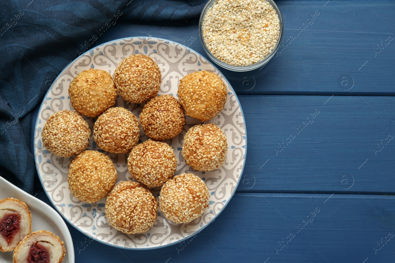 Photo of Delicious sesame balls on blue wooden table, flat lay. Space for text