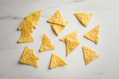 Photo of Flat lay composition of tasty tortilla chips (nachos) on white table