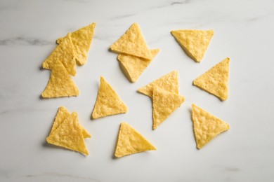 Flat lay composition of tasty tortilla chips (nachos) on white table